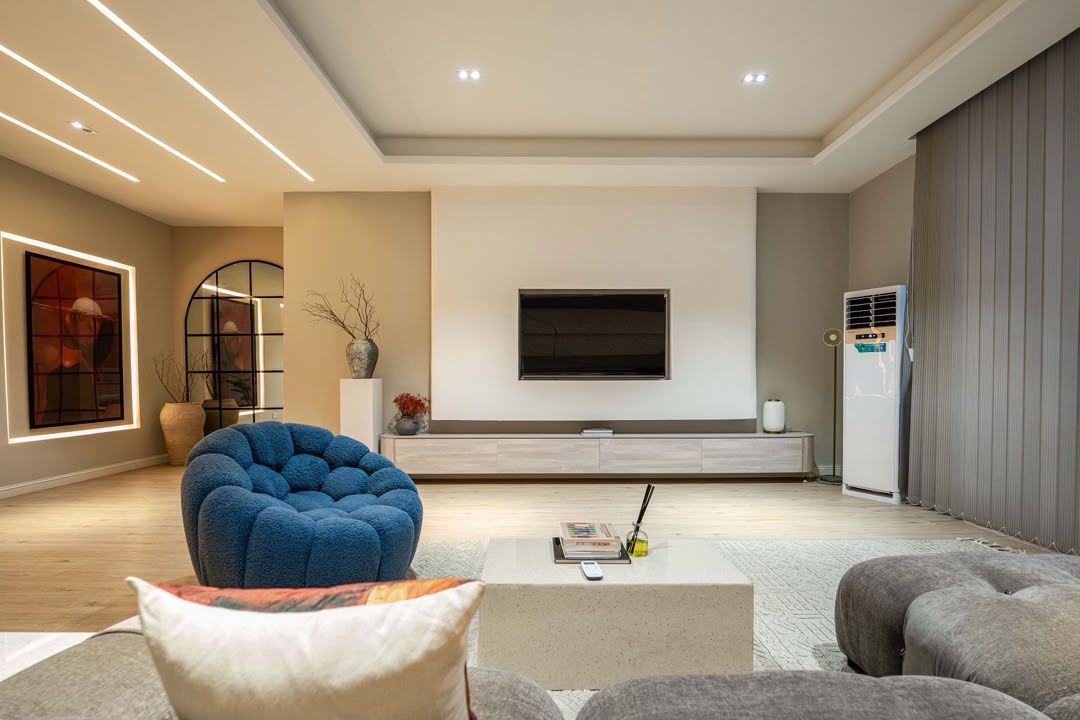 Stylish Lekki apartment TV lounge with blue accent chair